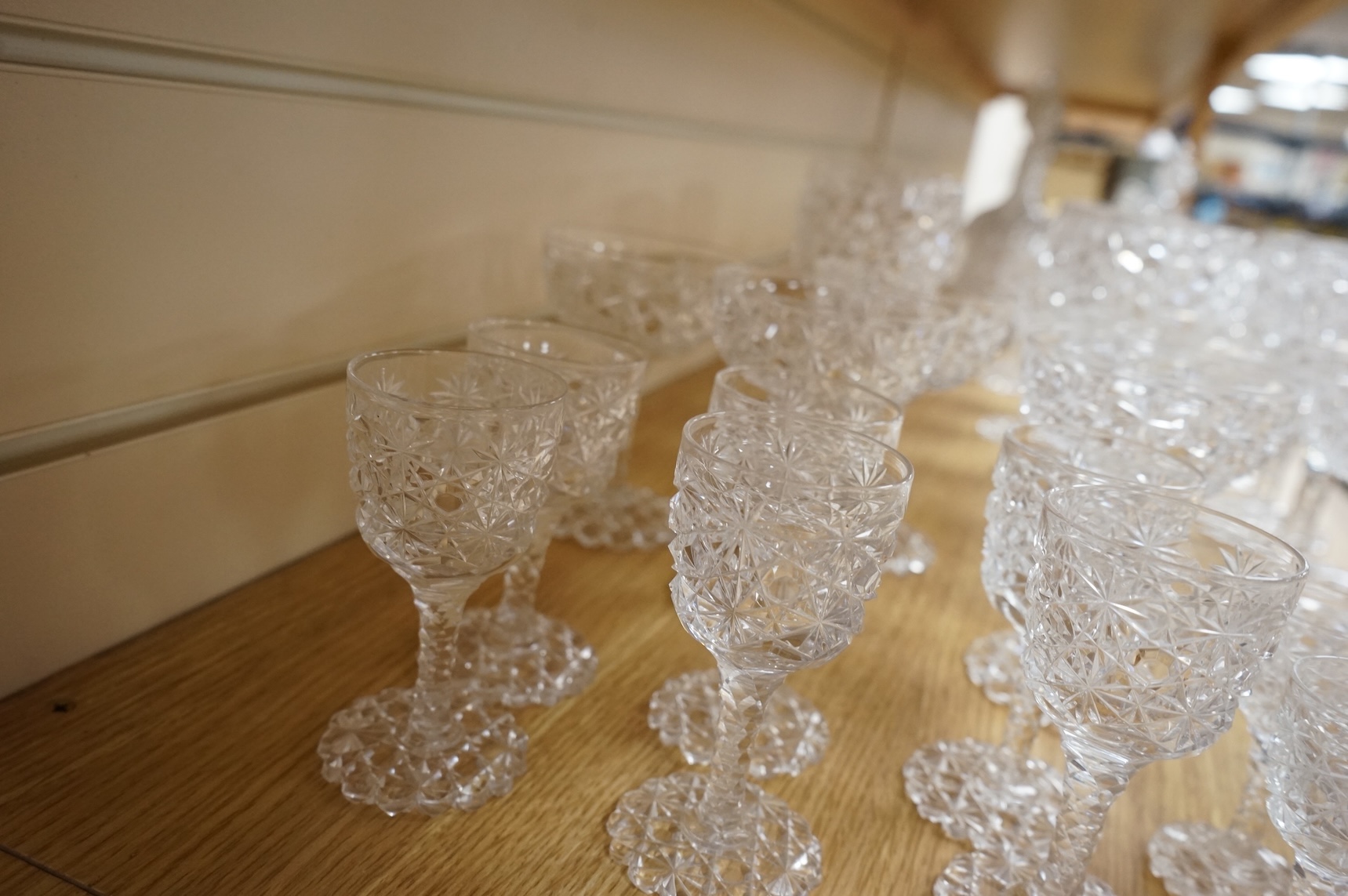 A Victorian heavy hobnail and star cut suite of table glass to include champagnes glasses and two decanters, largest 29cm high